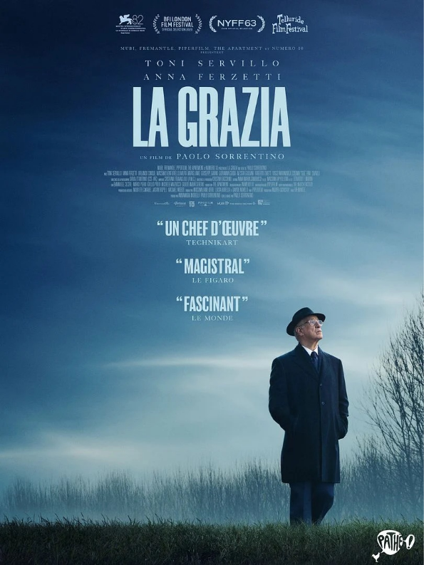 Affiche du film La Grazia, un homme en costume noir et chapeau noir se tient debout devant un paysage brumeux et un ciel sombre.